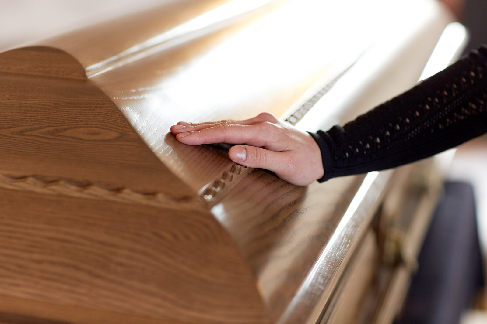 frau-hand-auf-sarg-sagro